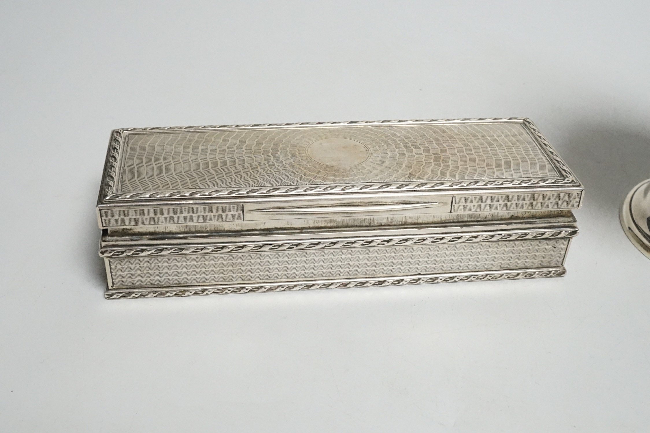 A George V engine turned rectangular silver box and cover by Goldsmiths & Silversmiths Co Ltd, London, 1911, 15.2cm and an Edwardian silver sugar caster, same maker, London, 1906, 15.5oz.